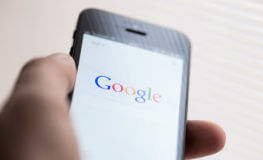 hand held mobile device with Google search engine open on the screen
